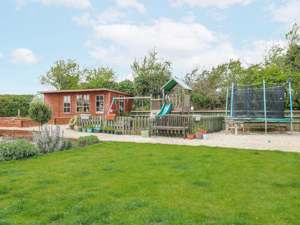 A garden with a shed, playground, and trampoline at Brecks Cottage Moorhouse near Tuxford