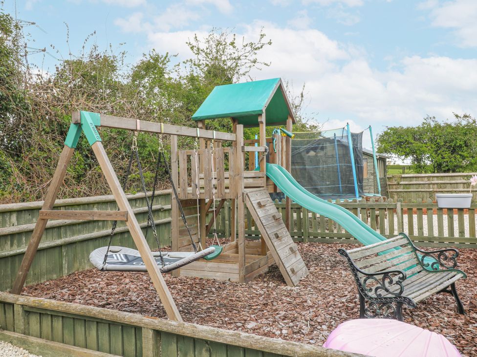 A playground with swings and a slide at Brecks Cottage in Moorhouse near Tuxford