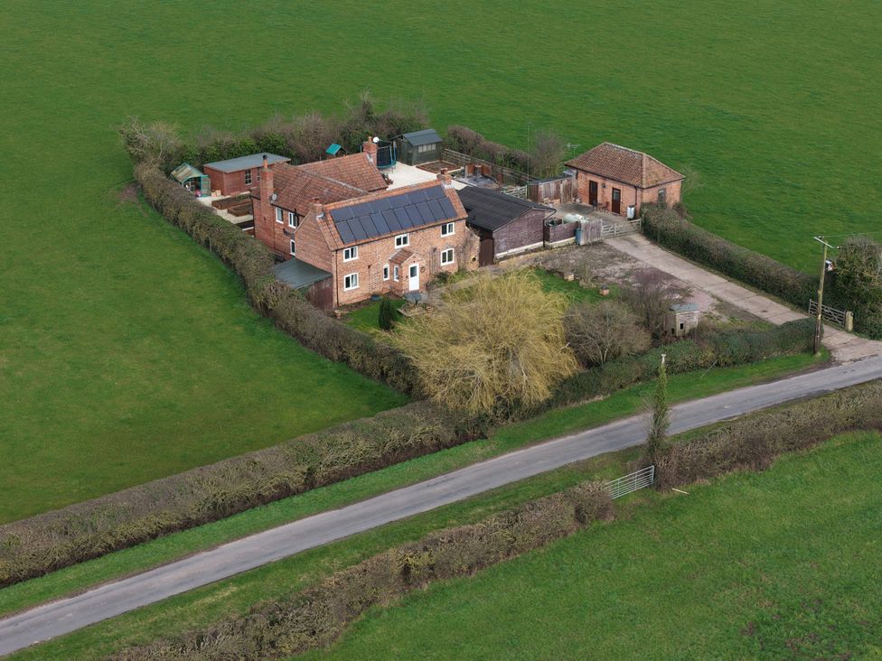 An outdoor view of a house with a garden and solar panels at Brecks Cottage in Moorhouse near Tuxford