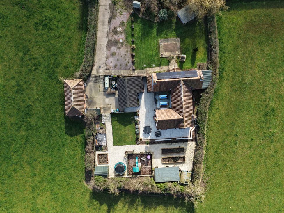 An aerial view of a house with a garden and patio at Brecks Cottage Moorhouse near Tuxford