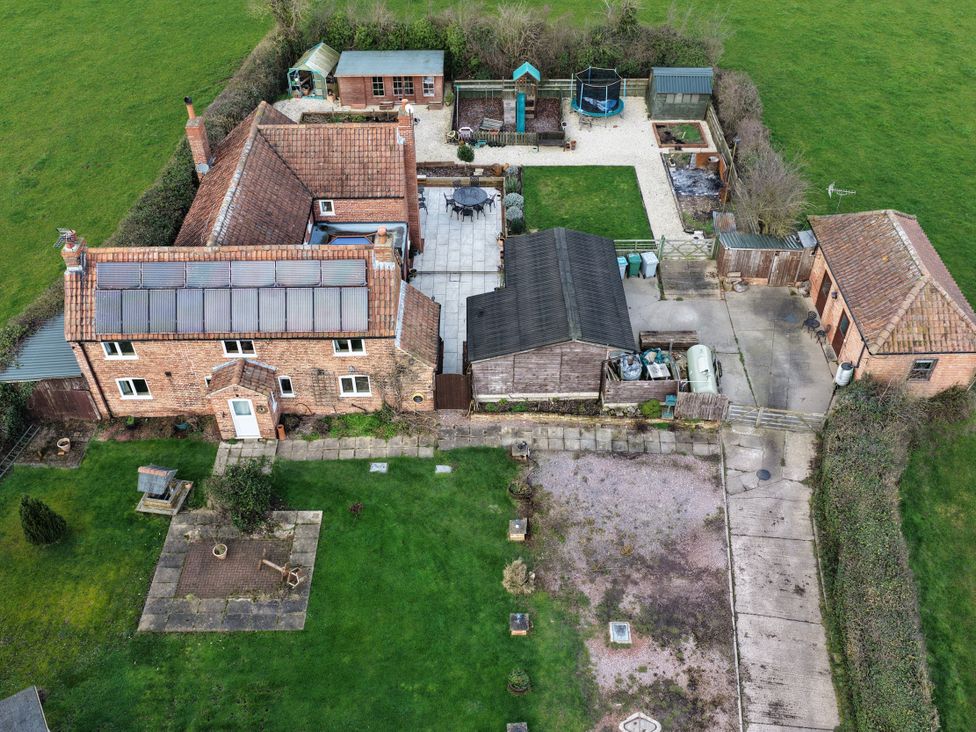 An outdoor area with a house, garden, shed, and trampoline at Brecks Cottage in Moorhouse near Tuxford