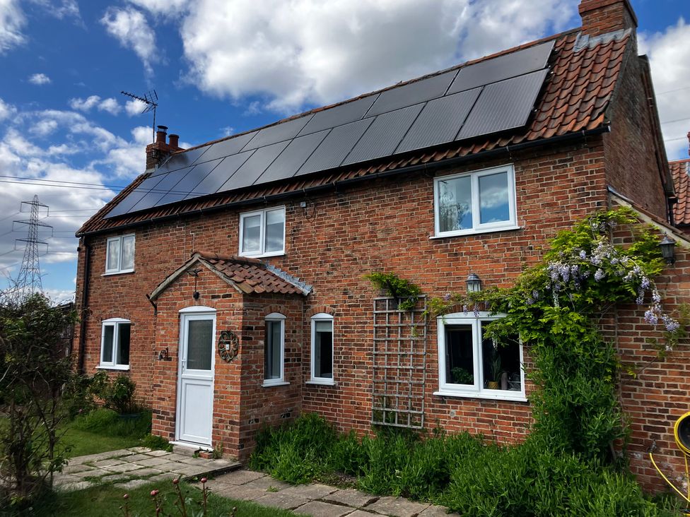 A house with solar panels and plants in the garden at Brecks Cottage Moorhouse near Tuxford