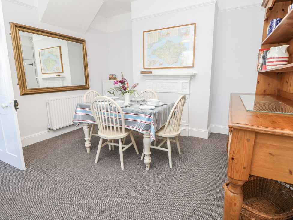 A dining room with a table and chairs at Bay Tree Cottage in Shanklin