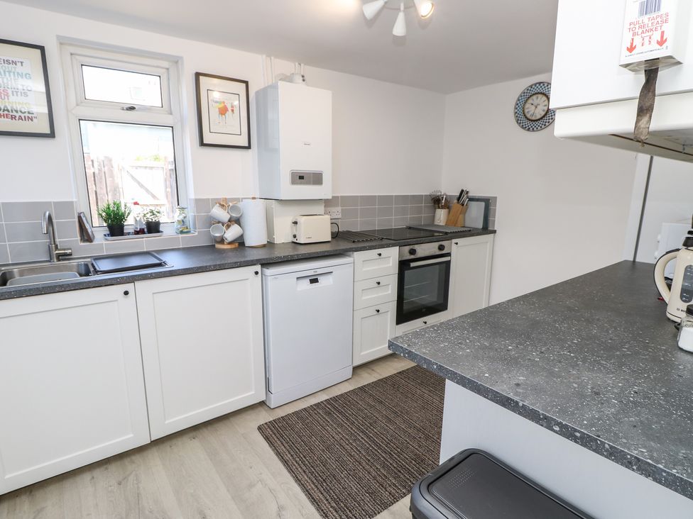 A kitchen with sink, counter, and appliances at Bay Tree Cottage in Shanklin