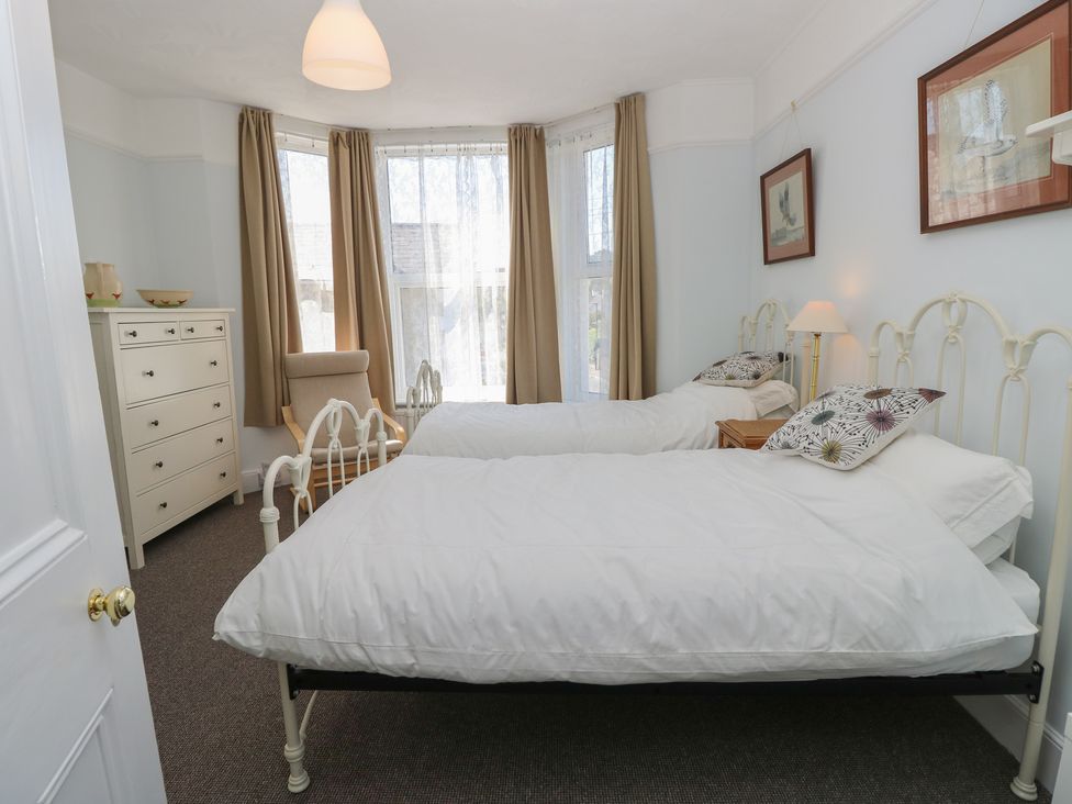 A bedroom with two beds and a dresser at Bay Tree Cottage in Shanklin