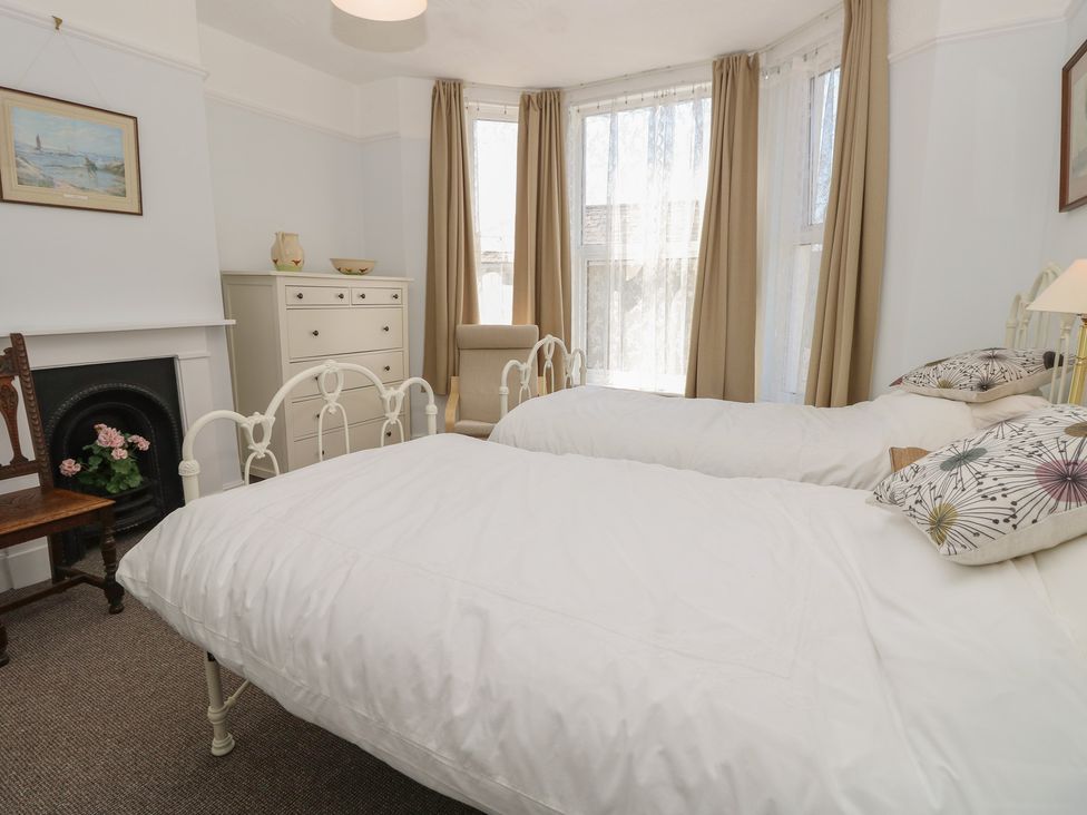 A bedroom with twin beds and a dresser at Bay Tree Cottage in Shanklin