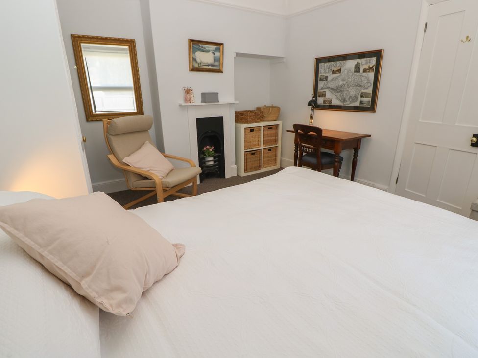 A bedroom with a bed and chair at Bay Tree Cottage in Shanklin