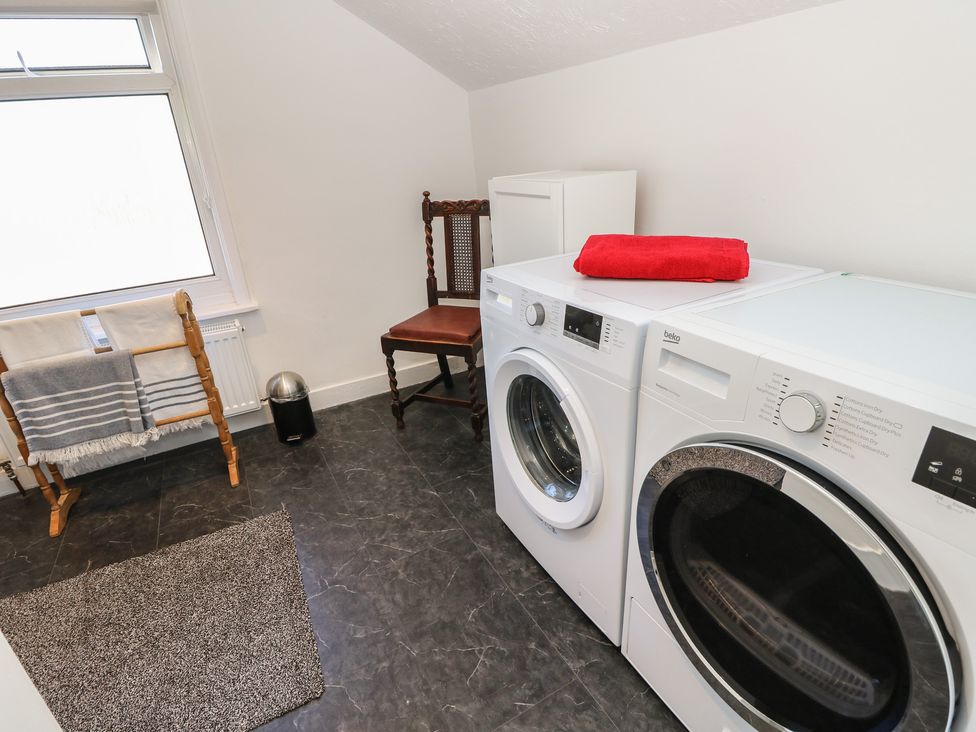 A laundry room with a washing machine and tumble dryer at Bay Tree Cottage in Shanklin