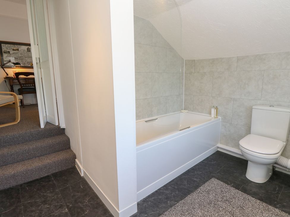 A bathroom with a bathtub and toilet at Bay Tree Cottage in Shanklin