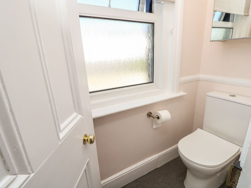 A bathroom with a toilet and a window at Bay Tree Cottage in Shanklin