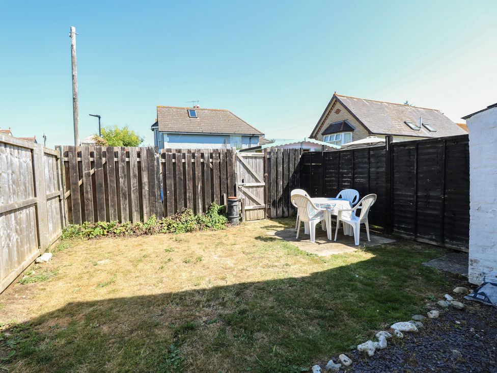A garden with a table and chairs at Bay Tree Cottage in Shanklin