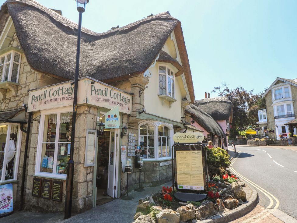 A store front with a menu board and flowers at Pencil Cottage in Shanklin