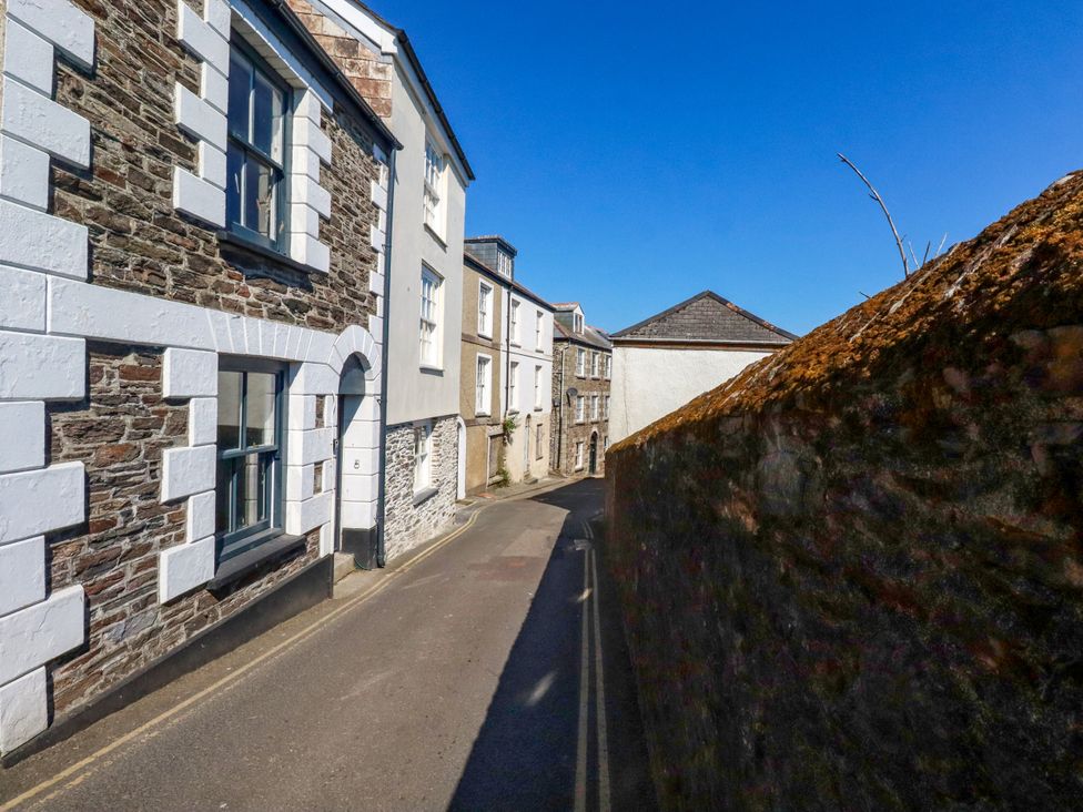 A street view with buildings and a wall at Whalebone Cottage in St. Austell
