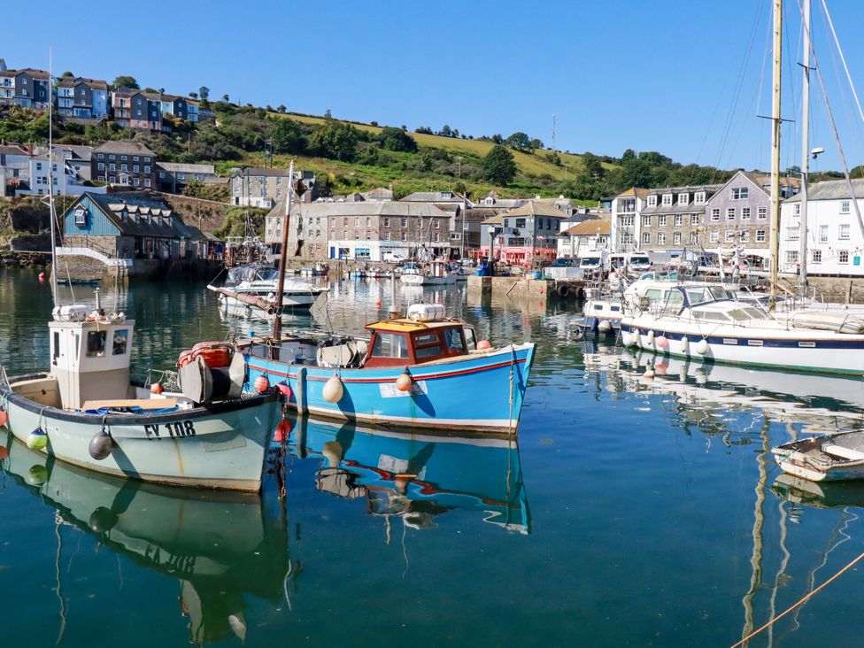 A harbor with boats and buildings at Whalebone Cottage in St. Austell