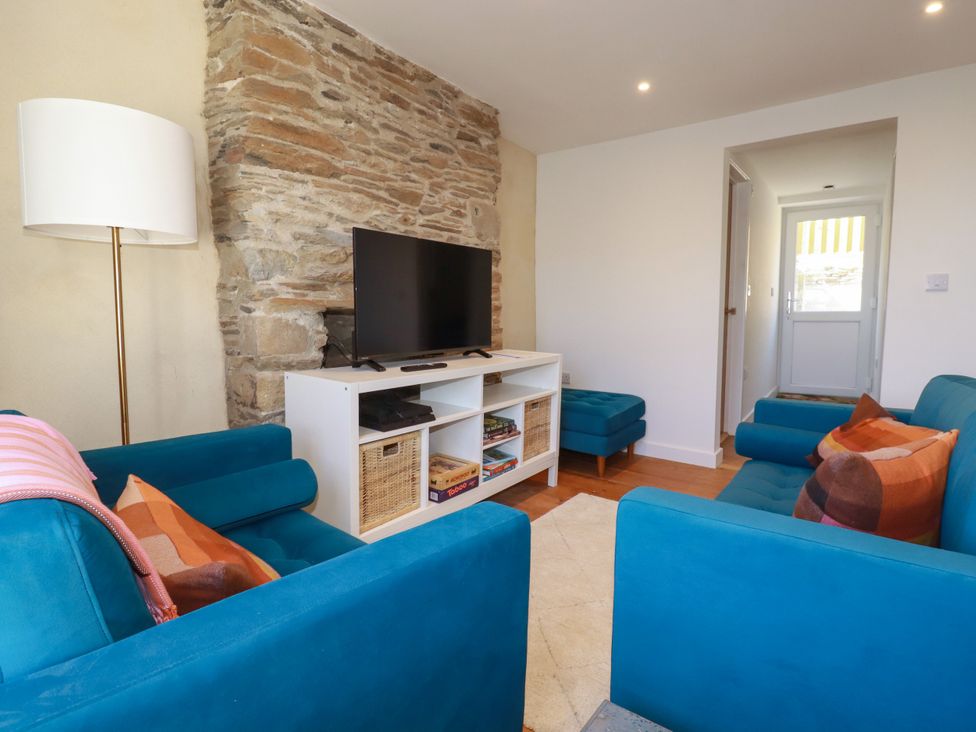 A living room with a television and seating area at Whalebone Cottage in St. Austell