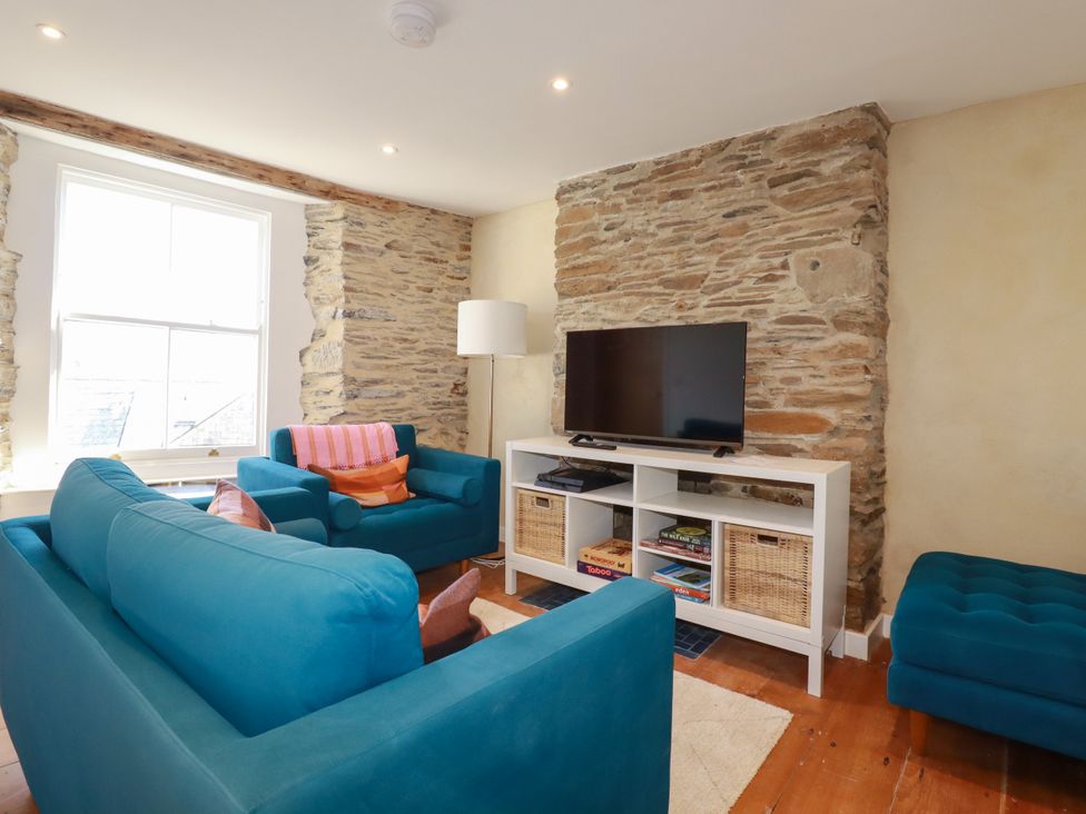A living room with a television on a shelf at Whalebone Cottage, St. Austell