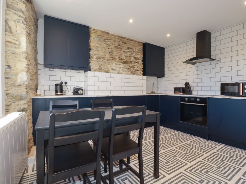 A kitchen with a table and chairs at Whalebone Cottage St. Austell