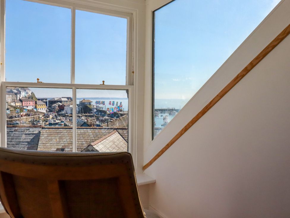 A window showing a view of a harbor at Whalebone Cottage in St. Austell