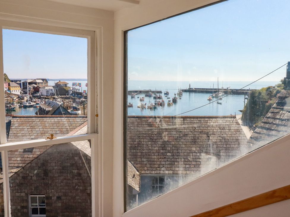 A view from a window overlooking a marina with boats at Whalebone Cottage in St. Austell