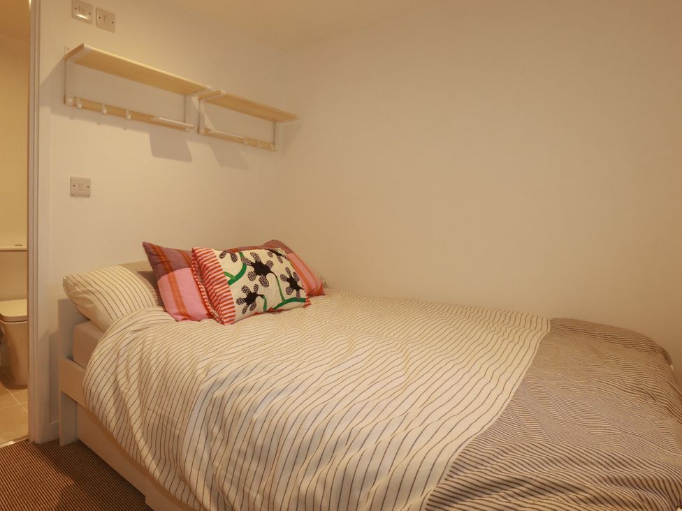 A bedroom with a bed and pillows at Whalebone Cottage St. Austell