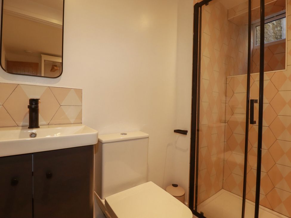 A bathroom featuring a sink, toilet, and shower at Whalebone Cottage, St. Austell