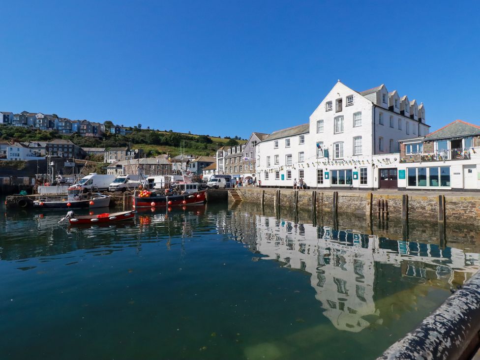 A harbor with boats and buildings at Whalebone Cottage in St. Austell