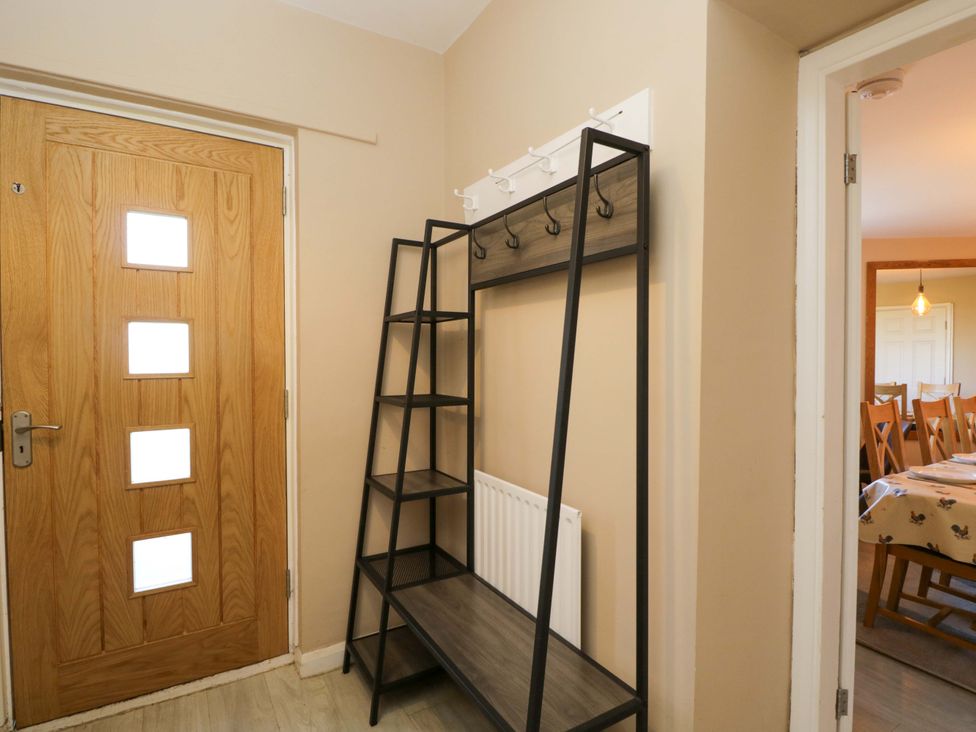 A hallway with a coat rack and front door at 3 Woods Farm House in Chippenham