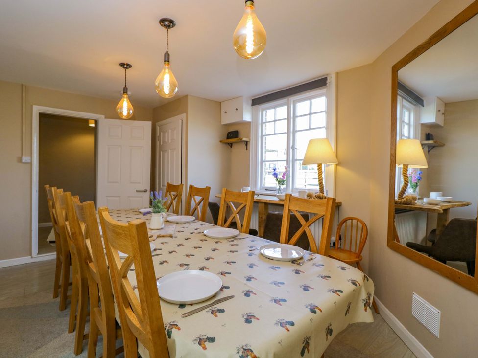 A dining room with a large table and chairs at 3 Woods Farm House in Chippenham