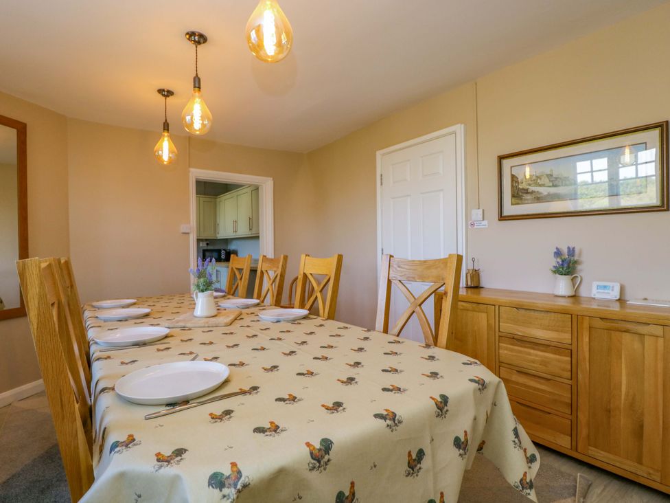 A dining room with a long table and wooden chairs at 3 Woods Farm House in Chippenham