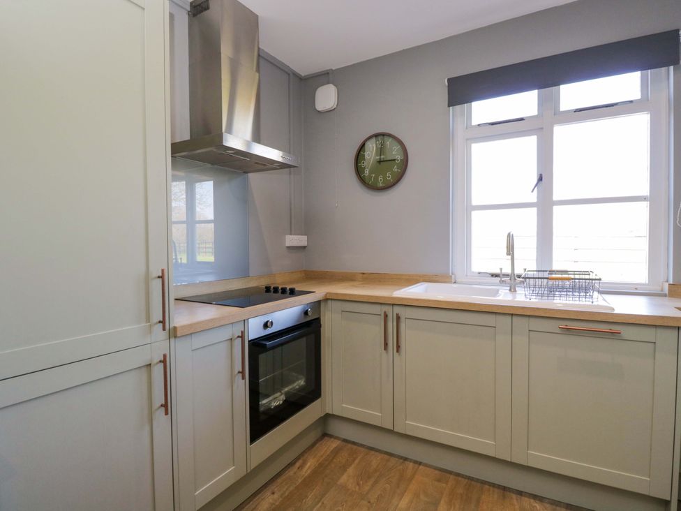 A kitchen with a sink and stove at 3 Woods Farm House in Chippenham