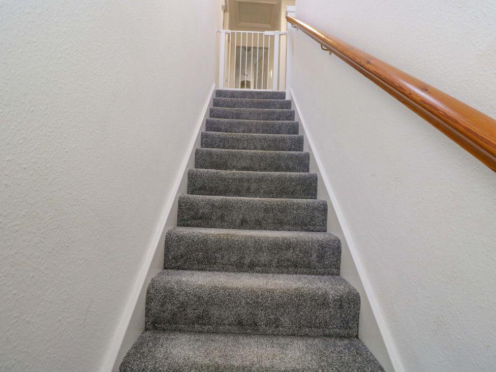 A staircase with grey carpet and a handrail at 3 Woods Farm House in Chippenham