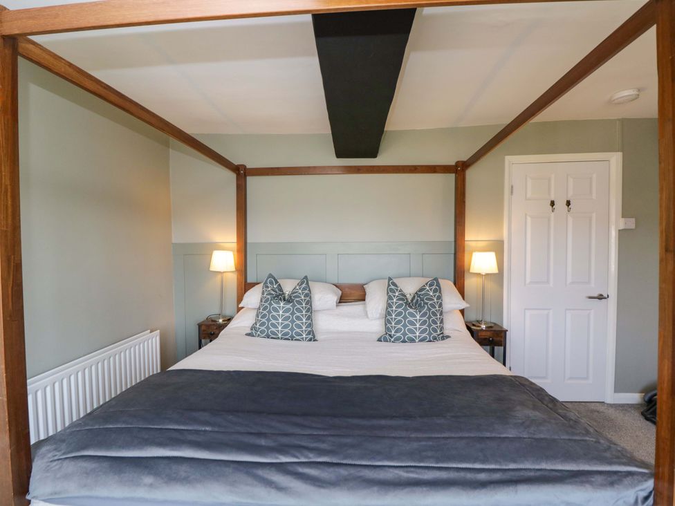 A bedroom with a four poster bed and bedside tables at 3 Woods Farm House, Chippenham