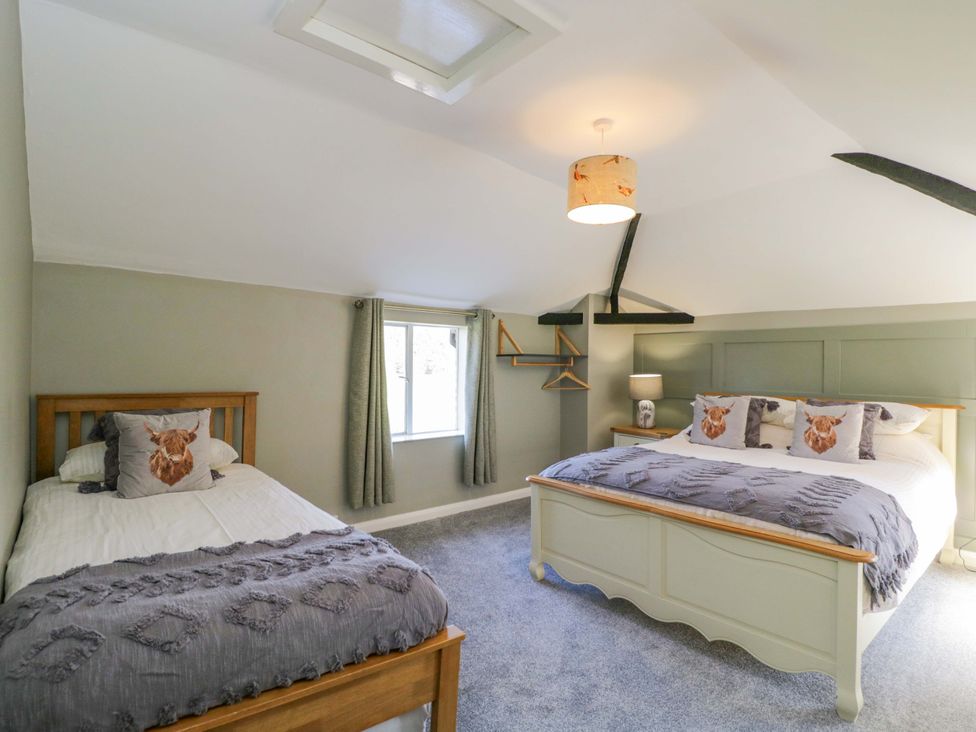 A bedroom with two beds and a lamp at 3 Woods Farm House in Chippenham