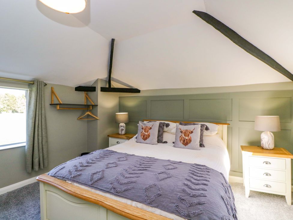 A bedroom with a bed and side tables at 3 Woods Farm House in Chippenham