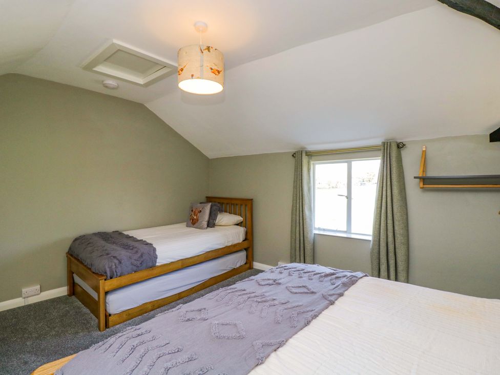 A bedroom with two beds and a window at 3 Woods Farm House in Chippenham