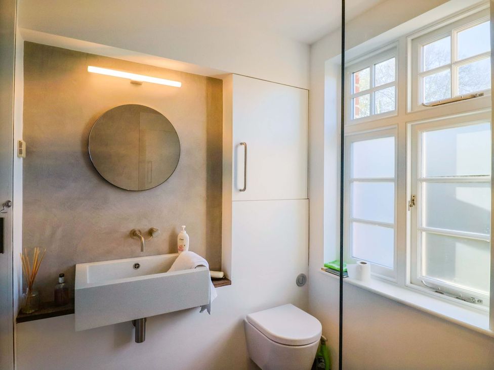 A bathroom with a wash basin and toilet at Bredy Cottages in Burton Bradstock