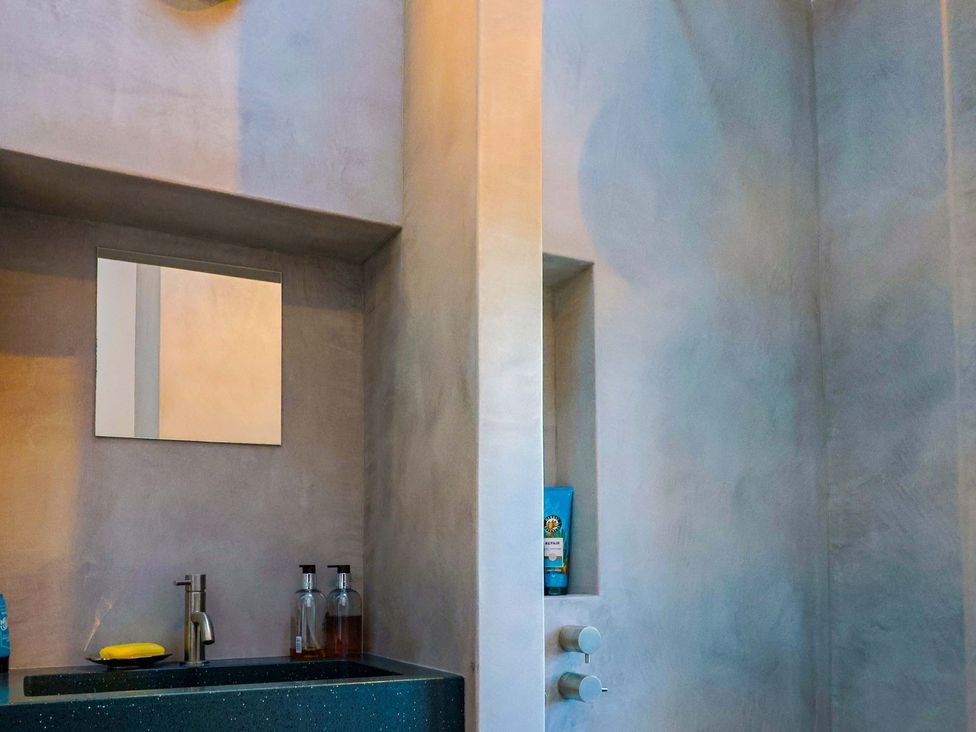 A bathroom with a sink and mirror at Bredy Cottages in Burton Bradstock