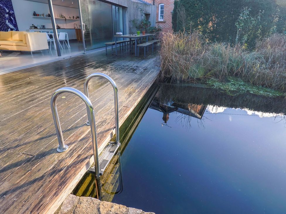 A deck with a ladder leading to water at Bredy Cottages Burton Bradstock