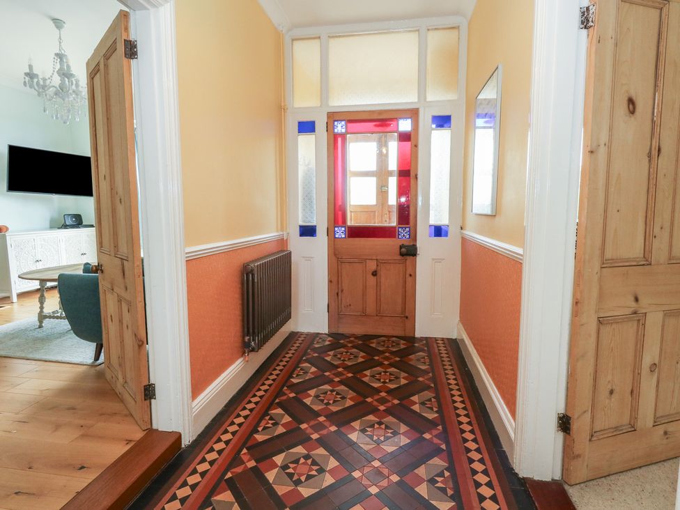 A hallway with patterned flooring and a front door at Millmead House Portesham