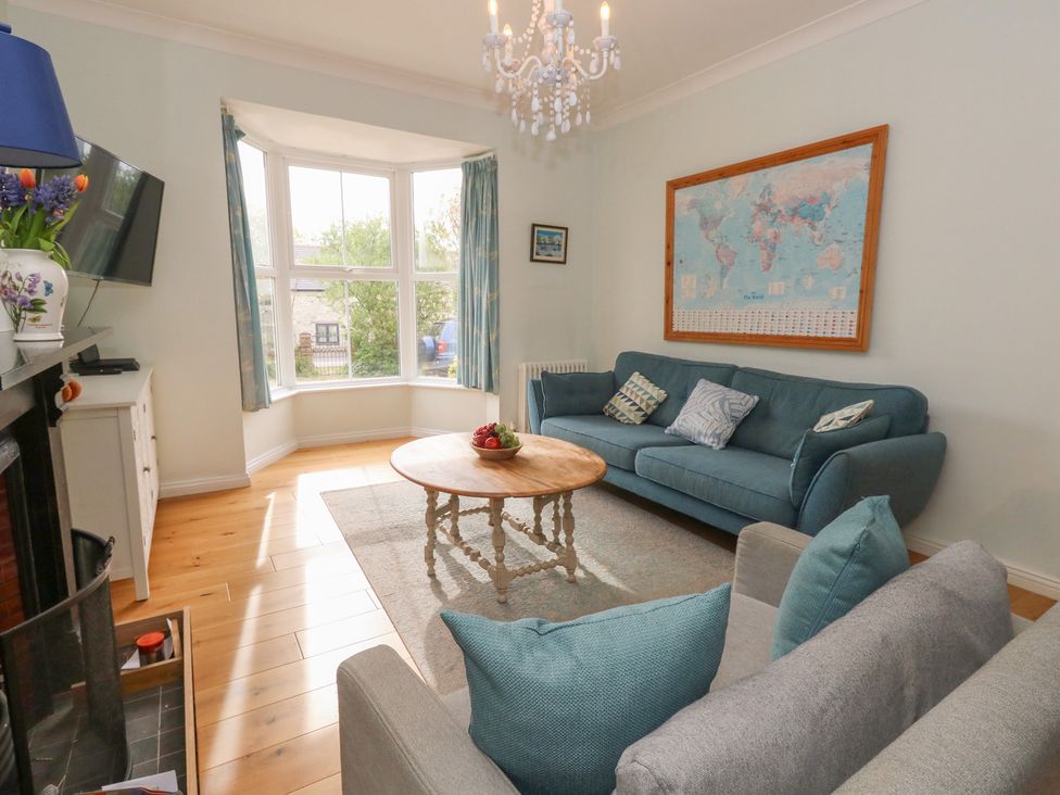 A living room with a sofa, coffee table and television at Millmead House in Portesham