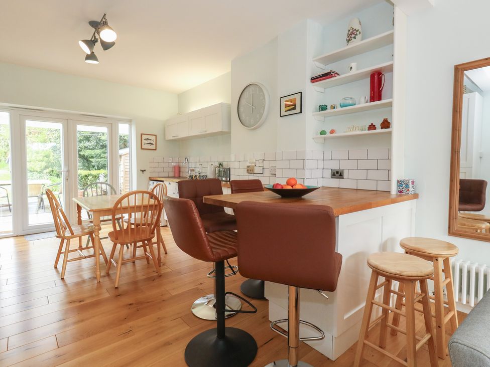 A kitchen with a dining table and bar stools at Millmead House in Portesham