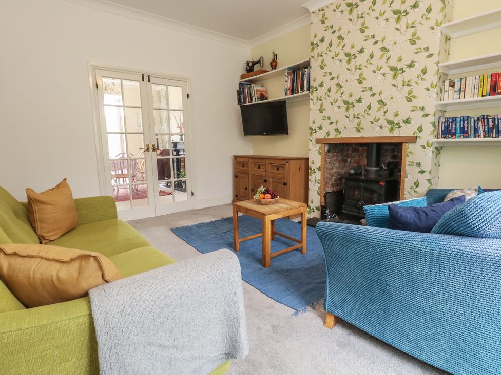A living room with a green sofa and blue armchair at Millmead House in Portesham