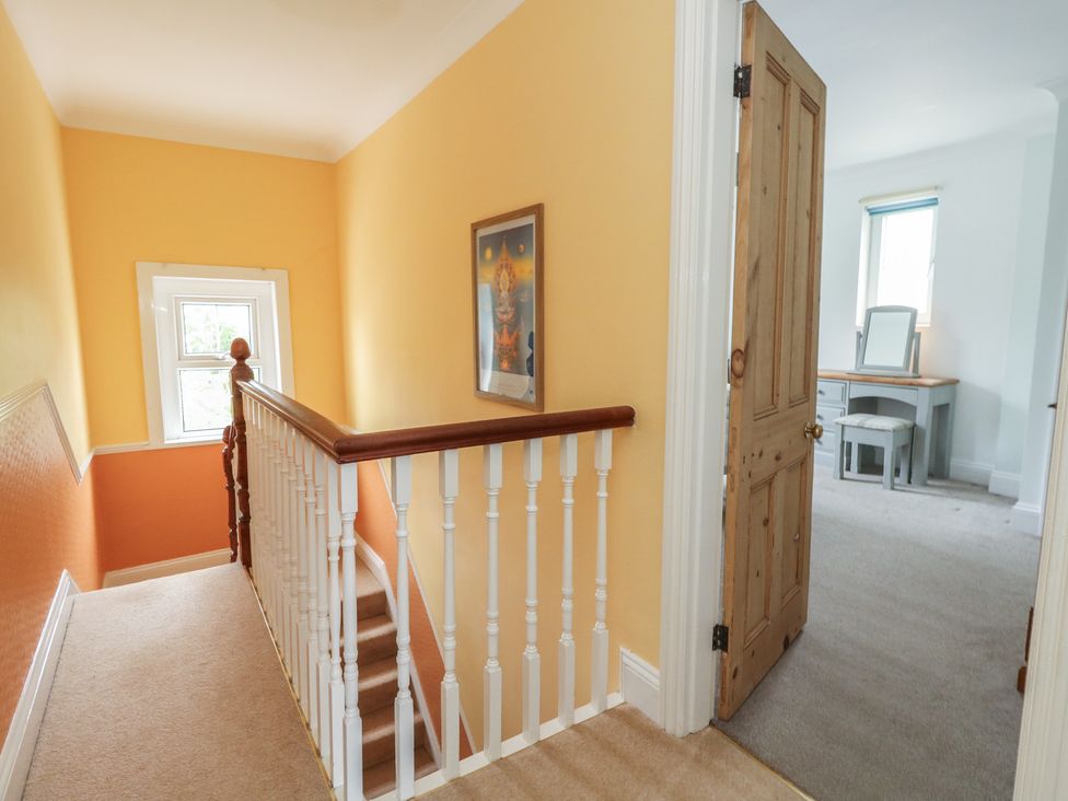 A hallway with stairs and a door leading to another room at Millmead House Portesham