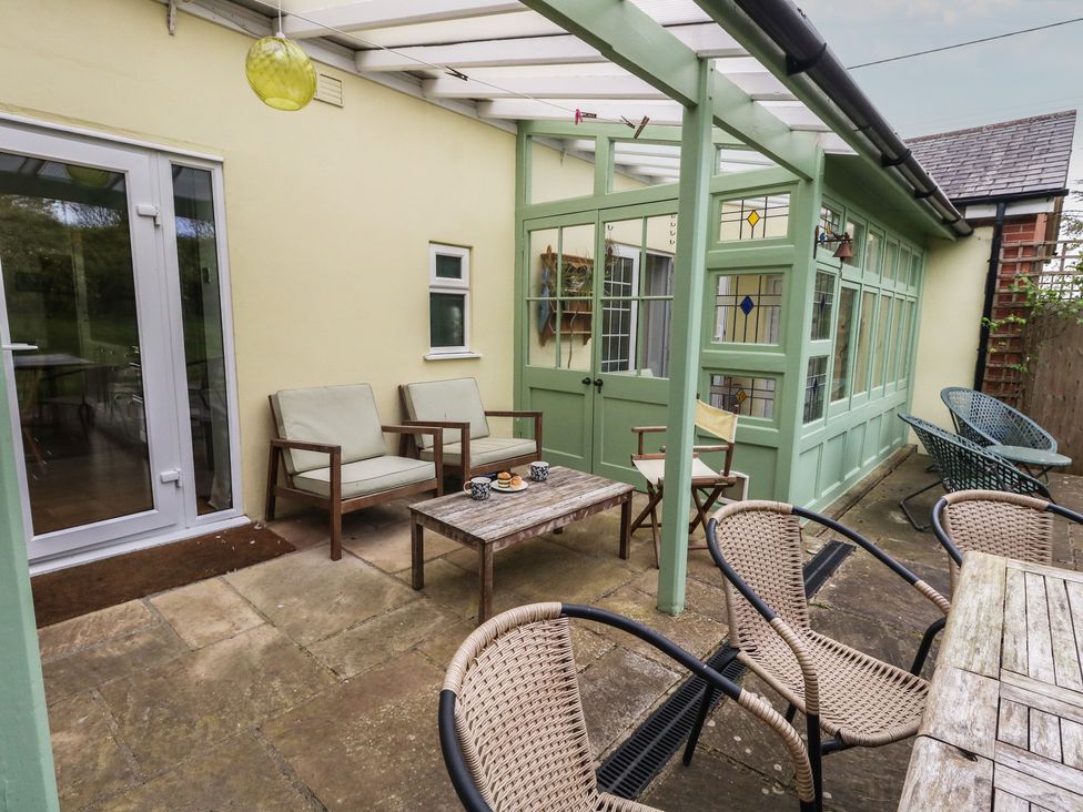 A conservatory with chairs and a table at Millmead House Portesham