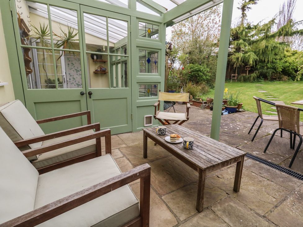 A conservatory with seating and a table at Millmead House Portesham