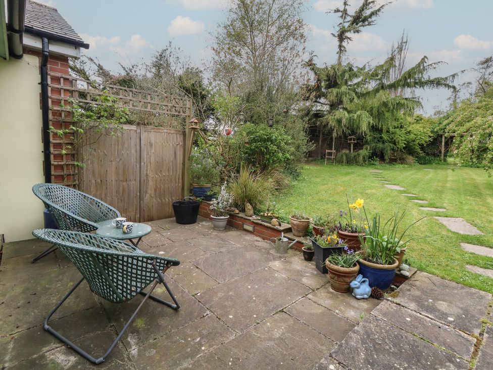 A garden with chairs and flower pots at Millmead House in Portesham
