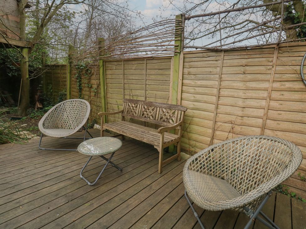 A garden with seating furniture and wooden flooring at Millmead House Portesham