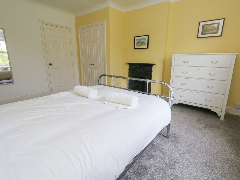A bedroom with a bed and wardrobe at Millmead House in Portesham