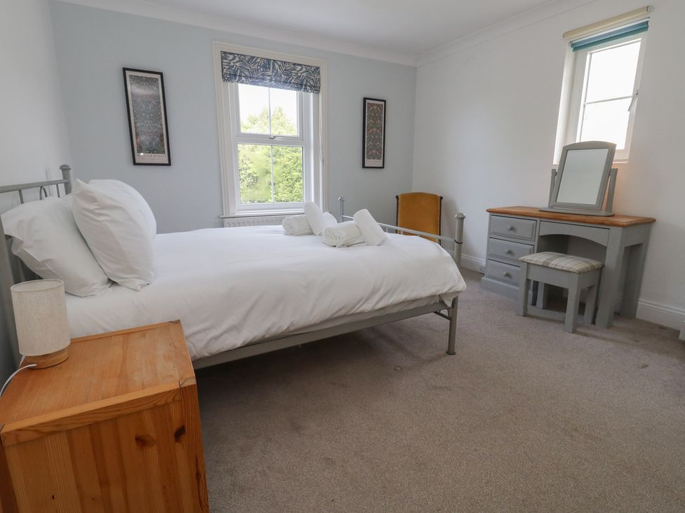 A bedroom with a bed and a dressing table at Millmead House in Portesham