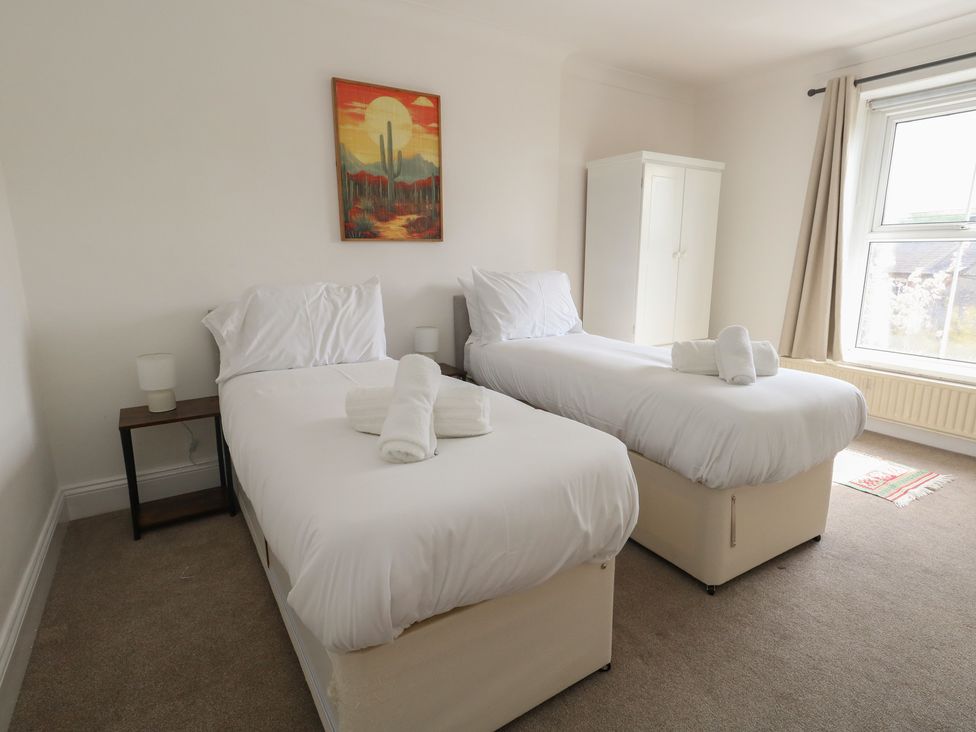 A bedroom with two beds and a wardrobe at Millmead House in Portesham